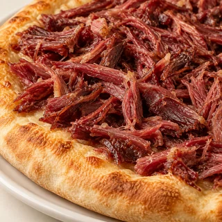 Pizza Carne seca — detalhe ilustrativo de carne seca desfiada; não representa a receita completa, que precisa de confirmação